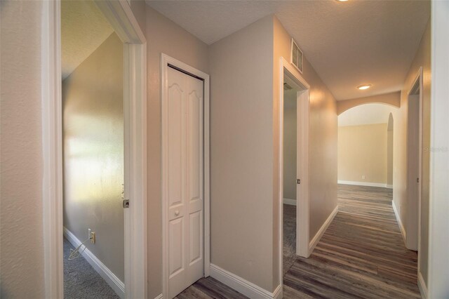 19247 Otters Wick Way, Land O Lakes, FL 34638 - hallway featuring wood finished floors, arched walkways, baseboards, and a textured ceiling