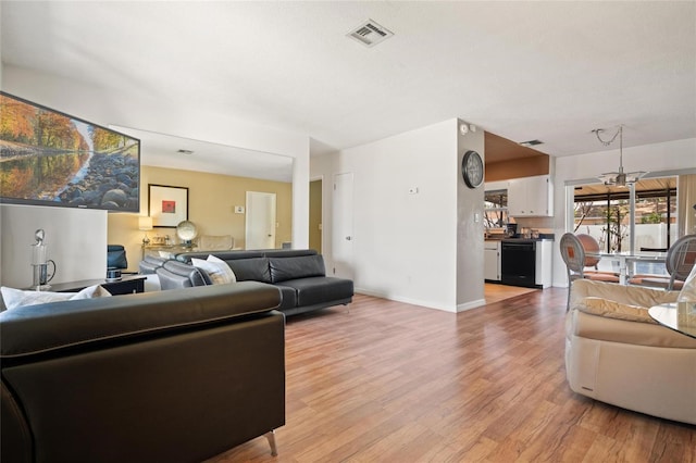 2048 64th Ave S, Saint Petersburg, FL 33712 - living area featuring light wood-style floors, a chandelier, and baseboards