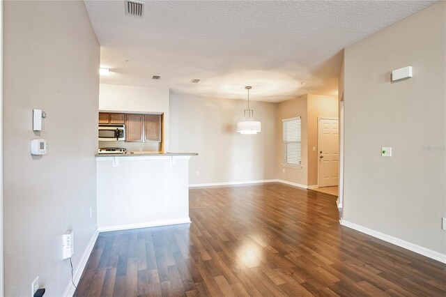 4991 Key Lime Dr Unit 104, Jacksonville, FL 32256 - unfurnished living room featuring dark wood finished floors, baseboards, and a textured ceiling