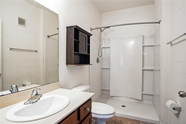 4991 Key Lime Dr Unit 104, Jacksonville, FL 32256 - bathroom featuring toilet, a stall shower, vanity, and tile patterned floors