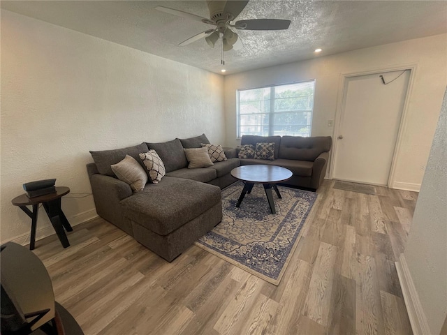 2011 58th Ave N Unit 20, Saint Petersburg, FL 33714 - living room featuring light wood finished floors, a textured ceiling, ceiling fan, baseboards, and a textured wall