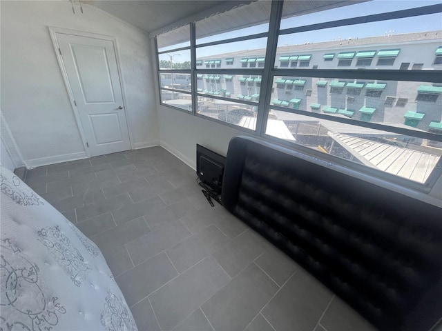 2011 58th Ave N Unit 20, Saint Petersburg, FL 33714 - unfurnished bedroom featuring dark tile patterned floors and baseboards