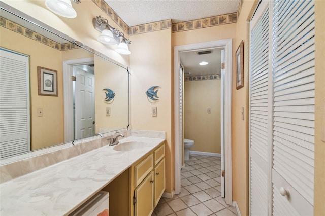 17980 Gulf Blvd Unit 505, Redington Shores, FL 33708 - bathroom with a closet, toilet, tile patterned floors, vanity, and a textured ceiling
