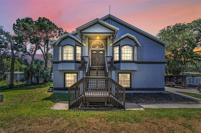 6521 Oelsner St, New Port Richey, FL 34652 - view of front facade featuring stairway, a yard, and stucco siding