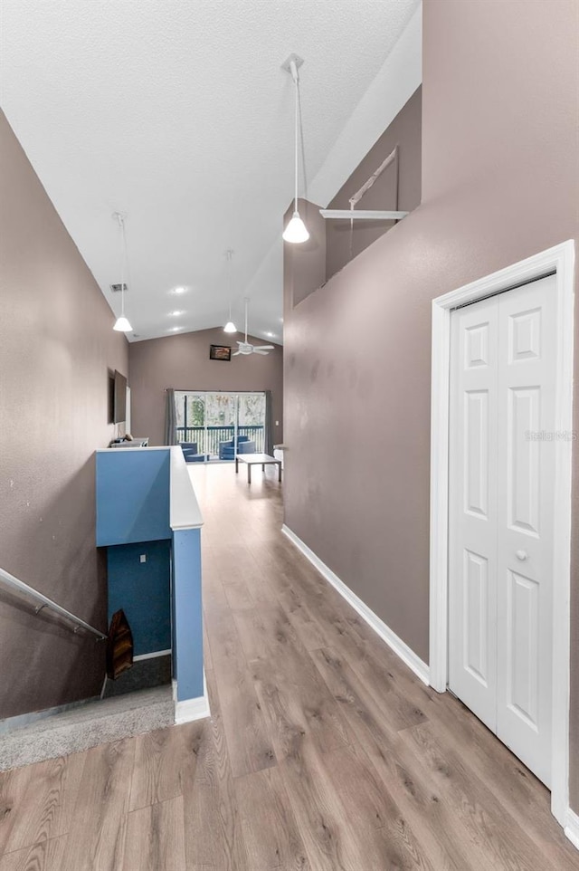 6521 Oelsner St, New Port Richey, FL 34652 - corridor featuring lofted ceiling, wood finished floors, and baseboards