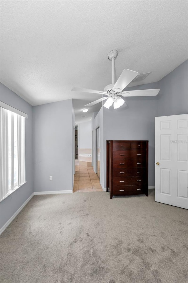 6521 Oelsner St, New Port Richey, FL 34652 - unfurnished bedroom with carpet, baseboards, a textured ceiling, and ceiling fan