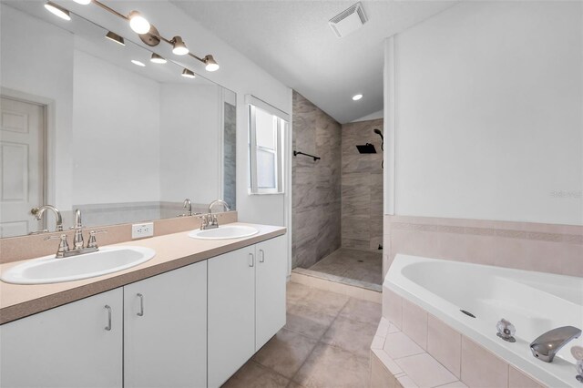 6521 Oelsner St, New Port Richey, FL 34652 - full bathroom with a garden tub, a tile shower, double vanity, vaulted ceiling, and tile patterned flooring