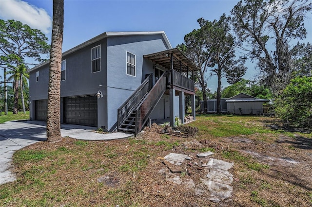 6521 Oelsner St, New Port Richey, FL 34652 - back of property featuring an attached garage, driveway, stairway, and stucco siding