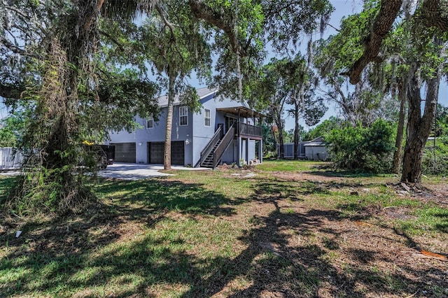 6521 Oelsner St, New Port Richey, FL 34652 - view of grassy yard with stairs, a garage, and a wooden deck