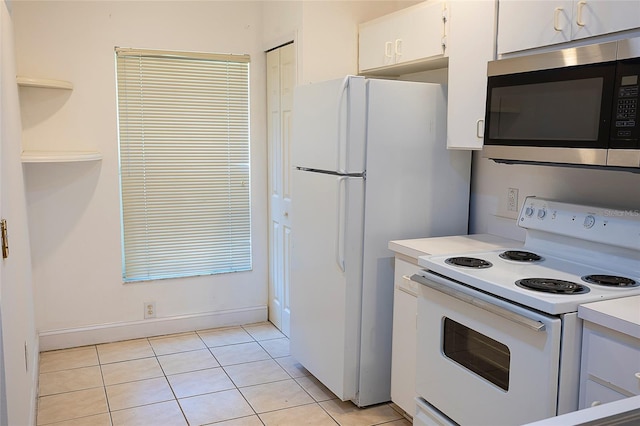 8545 Hunters Key Cir, Tampa, FL 33647 - kitchen featuring white appliances, white cabinets, light countertops, light tile patterned floors, and baseboards
