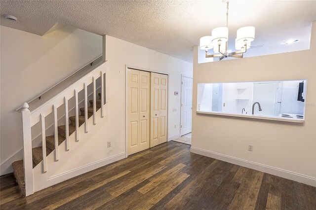 8545 Hunters Key Cir, Tampa, FL 33647 - entrance foyer featuring dark wood finished floors, a chandelier, baseboards, stairs, and a textured ceiling