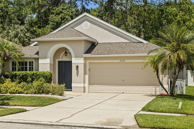 25332 Lexington Oaks Blvd, Wesley Chapel, FL 33544 - view of front of house with stucco siding, a garage, a shingled roof, driveway, and a front yard