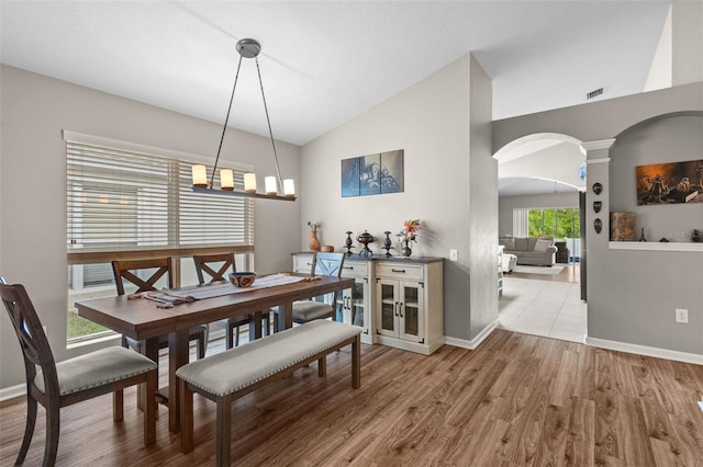 25332 Lexington Oaks Blvd, Wesley Chapel, FL 33544 - dining room featuring arched walkways, wood finished floors, baseboards, ornate columns, and high vaulted ceiling