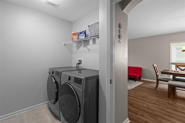 25332 Lexington Oaks Blvd, Wesley Chapel, FL 33544 - laundry room with washing machine and dryer, a textured ceiling, baseboards, and wood finished floors