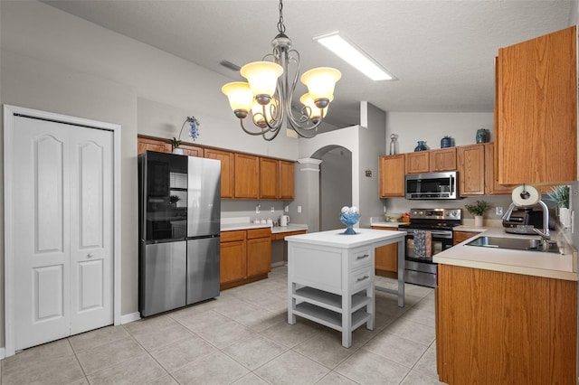 25332 Lexington Oaks Blvd, Wesley Chapel, FL 33544 - kitchen featuring appliances with stainless steel finishes, arched walkways, brown cabinetry, light countertops, and lofted ceiling