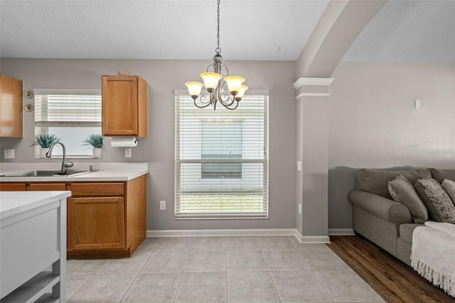 25332 Lexington Oaks Blvd, Wesley Chapel, FL 33544 - kitchen featuring a sink, a chandelier, light countertops, open floor plan, and plenty of natural light