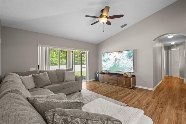 25332 Lexington Oaks Blvd, Wesley Chapel, FL 33544 - living room with arched walkways, wood finished floors, a ceiling fan, baseboards, and high vaulted ceiling