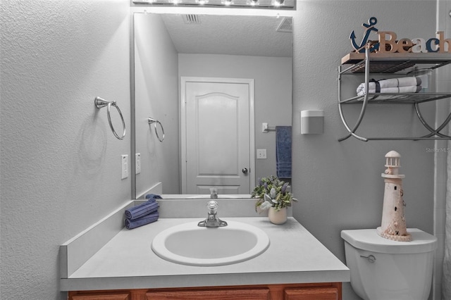 25332 Lexington Oaks Blvd, Wesley Chapel, FL 33544 - bathroom with toilet, vanity, a textured wall, and a textured ceiling