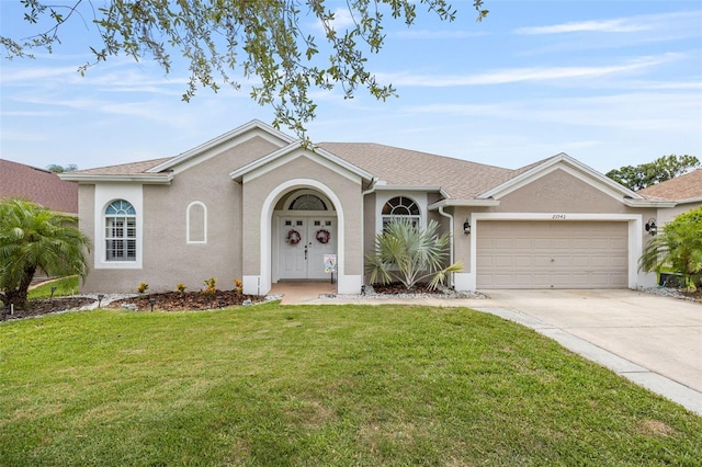 25942 Risen Star Dr, Wesley Chapel, FL 33544 - ranch-style home with driveway, an attached garage, a front lawn, and stucco siding