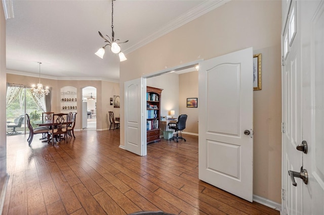 25942 Risen Star Dr, Wesley Chapel, FL 33544 - foyer entrance featuring a chandelier, ornamental molding, wood-type flooring, and arched walkways