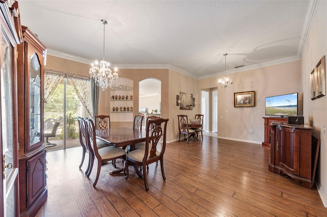 25942 Risen Star Dr, Wesley Chapel, FL 33544 - dining room featuring a chandelier, arched walkways, ornamental molding, wood-type flooring, and a textured ceiling