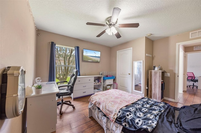 25942 Risen Star Dr, Wesley Chapel, FL 33544 - bedroom featuring wood-type flooring, an office area, a textured ceiling, and a ceiling fan
