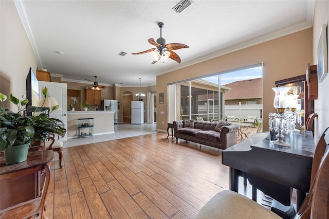25942 Risen Star Dr, Wesley Chapel, FL 33544 - living room featuring ceiling fan, light wood-style flooring, crown molding, a textured ceiling, and a chandelier