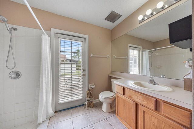 25942 Risen Star Dr, Wesley Chapel, FL 33544 - bathroom with tile patterned flooring, a tile shower, vanity, and plenty of natural light