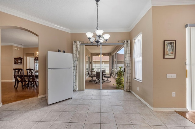 25942 Risen Star Dr, Wesley Chapel, FL 33544 - kitchen with freestanding refrigerator, arched walkways, a chandelier, light tile patterned floors, and ornamental molding