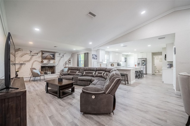 1416 Leighton Ave, Lakeland, FL 33803 - living area with lofted ceiling, light wood-style flooring, ornamental molding, a fireplace, and recessed lighting