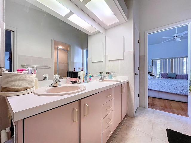 1599 Mcauliffe Ln, Palm Harbor, FL 34683 - ensuite bathroom featuring double vanity, ceiling fan, an enclosed shower, and tile patterned floors