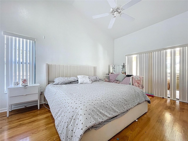1599 Mcauliffe Ln, Palm Harbor, FL 34683 - bedroom with multiple windows, light wood-style flooring, high vaulted ceiling, and ceiling fan