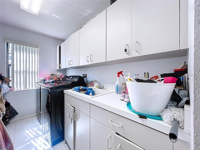 1599 Mcauliffe Ln, Palm Harbor, FL 34683 - laundry area featuring cabinet space, separate washer and dryer, a textured ceiling, and light tile patterned flooring