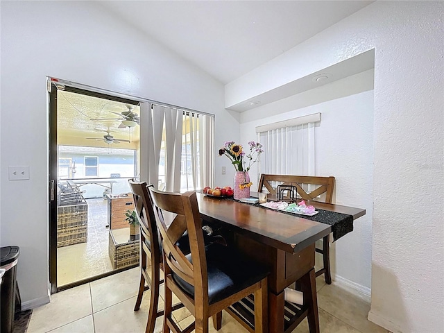1599 Mcauliffe Ln, Palm Harbor, FL 34683 - dining room with lofted ceiling, light tile patterned flooring, a ceiling fan, a textured wall, and baseboards
