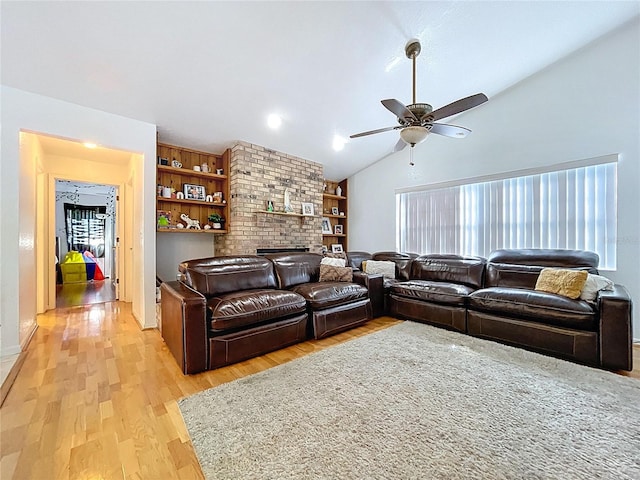 1599 Mcauliffe Ln, Palm Harbor, FL 34683 - living area featuring vaulted ceiling, light wood-style flooring, a ceiling fan, and a brick fireplace