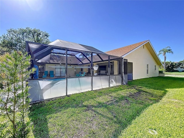 1599 Mcauliffe Ln, Palm Harbor, FL 34683 - back of property featuring stucco siding, a yard, an outdoor pool, and glass enclosure