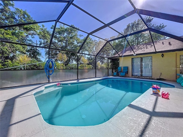 1599 Mcauliffe Ln, Palm Harbor, FL 34683 - outdoor pool featuring glass enclosure and a patio area