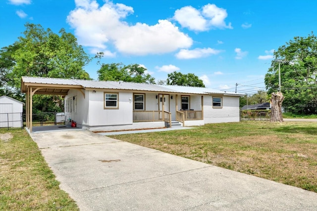 6020 N 50th St, Tampa, FL 33610 - single story home featuring covered porch, concrete driveway, metal roof, a carport, and a storage unit