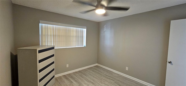 unfurnished bedroom featuring light wood-style flooring, baseboards, and ceiling fan