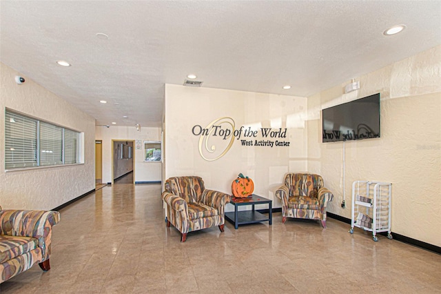 building lobby featuring a textured wall and recessed lighting