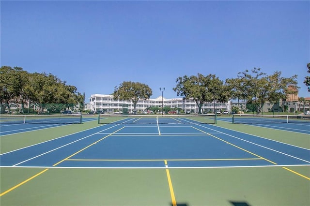 view of tennis court featuring community basketball court and fence