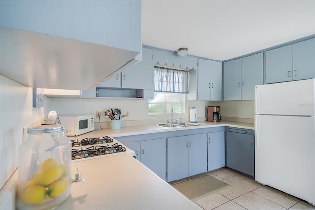 2220 S Coon Pt, Crystal River, FL 34429 - kitchen featuring white appliances, a sink, light countertops, light tile patterned floors, and blue cabinetry