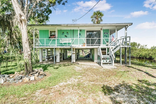 2220 S Coon Pt, Crystal River, FL 34429 - back of property featuring stairs, a carport, covered porch, and a yard