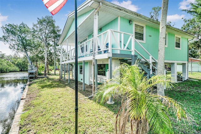 2220 S Coon Pt, Crystal River, FL 34429 - rear view of house featuring stairway, a yard, and a deck with water view