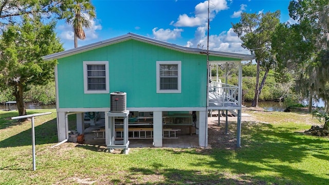 2220 S Coon Pt, Crystal River, FL 34429 - back of house featuring a lawn, a water view, central air condition unit, and a patio