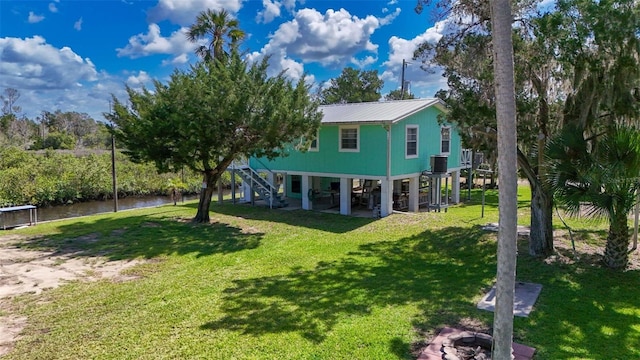 2220 S Coon Pt, Crystal River, FL 34429 - back of property featuring stairs, metal roof, a yard, a water view, and central air condition unit