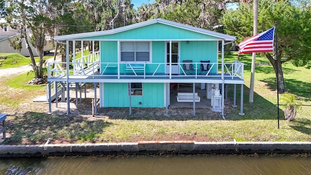 2220 S Coon Pt, Crystal River, FL 34429 - rear view of property with a deck with water view and a lawn