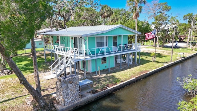 2220 S Coon Pt, Crystal River, FL 34429 - back of property with metal roof, a yard, a deck with water view, and stairway