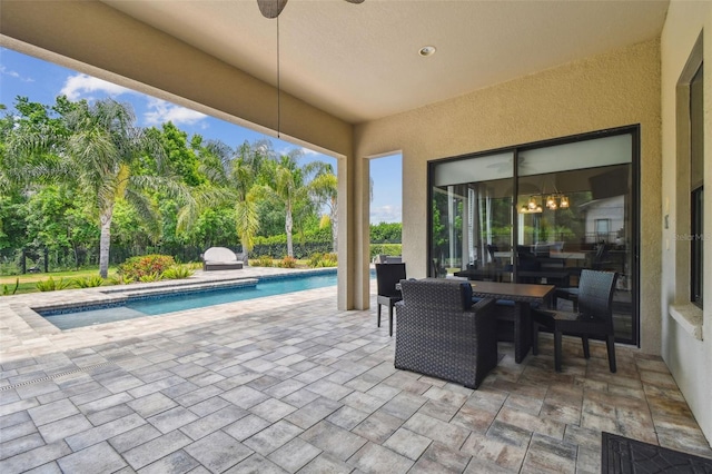 view of patio / terrace with an outdoor pool and view of wooded area