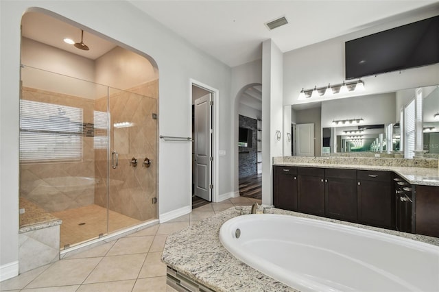 full bath featuring a garden tub, tile patterned floors, a stall shower, baseboards, and vanity